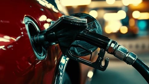 Closeup of a gas pump nozzle fueling a car