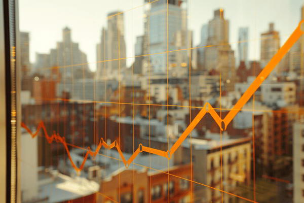 An increasing orange line graph is displayed on a window in front of a city