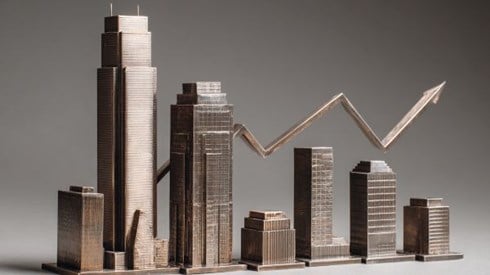metal figurines of commercial buildings lined up in decreasing size under a metal line graph arrow going up and down