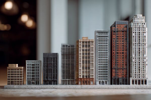scale model commercial buildings in a line increasing like a bar chart