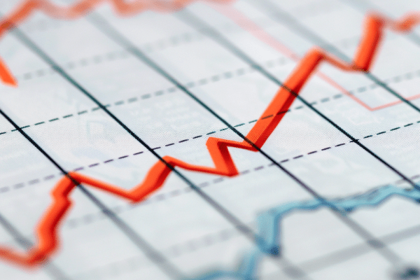 Top line graph on paper rising and bottom line graph on paper decreasing 