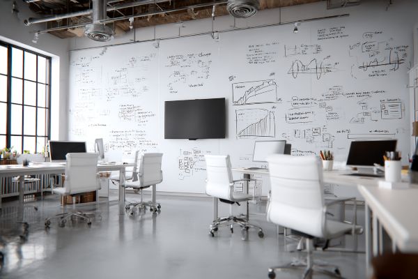 white professional office with flow charts and graphs drawn on a white wall