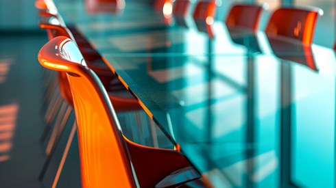 A close up of chairs at a glass conference table