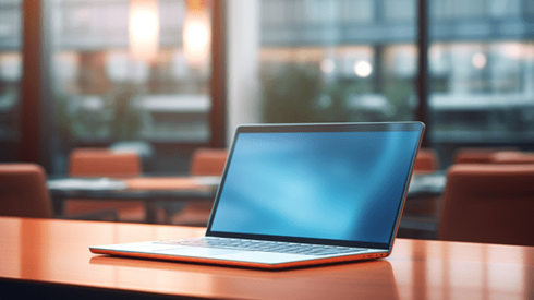 Open laptop on a table in a conference room