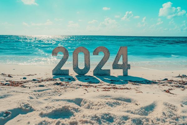 The number 2024 on a beach with white sand and turquoise water