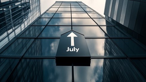 The word July with an arrow pointing up above it on the side of an office building