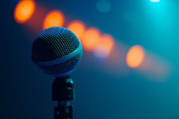 A microphone with orange spotlights and a blue background.