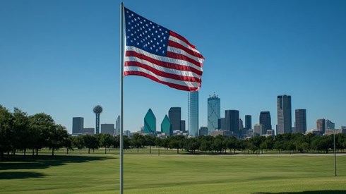 American flag flying in a field in front of the Dallas Texas skyline
