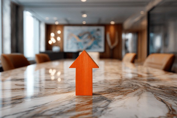 An orange arrow pointing up on top of a marble conference table