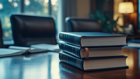 A stack of three books on top of a conference table
