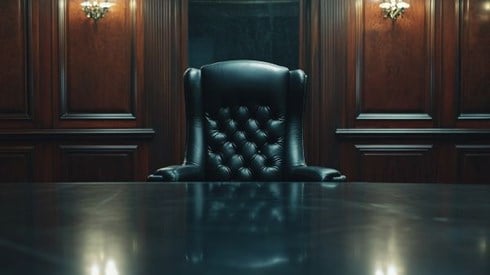 empty executive chair behind a conference table