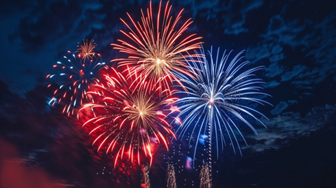 Red, white, and blue fireworks bursting in the night sky