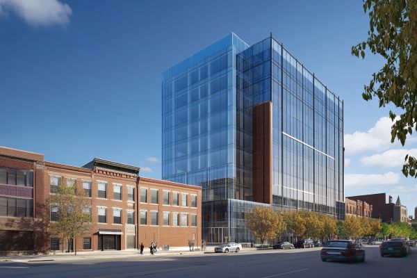 large glass multi-story building next to a smaller brick building