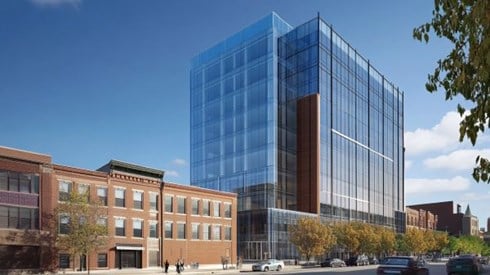 large glass multi-story building next to a smaller brick building