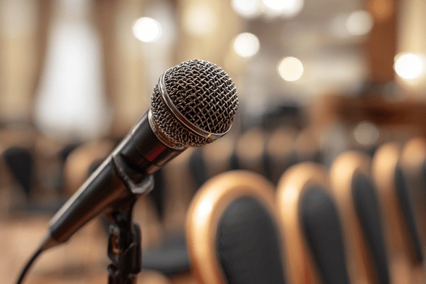 A microphone in front of empty chairs at a conference
