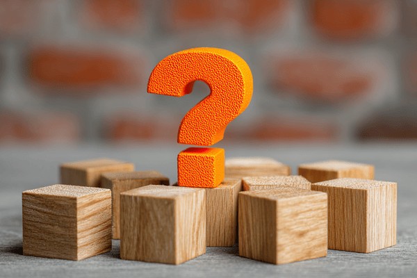 An orange question mark on top of wooden building blocks