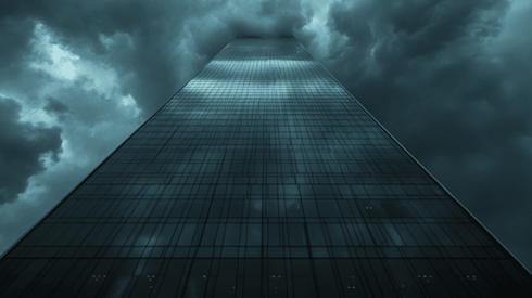 Looking up at storm clouds behind a skyscraper