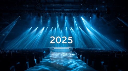 The number 2025 on a stage with spotlights shining above it