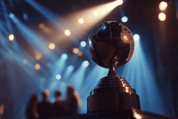 A trophy with a globe on top of it, sitting on a conference stage with spotlights