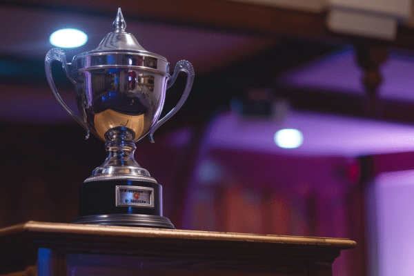 A silver trophy sitting on top of a speaker poduium