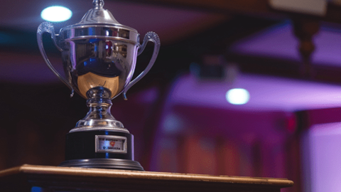 A silver trophy sitting on top of a speaker poduium