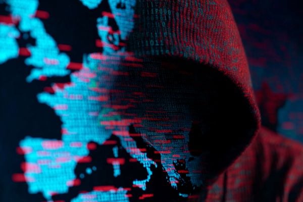 red hooded figure blending into a blue binary code map of Europe