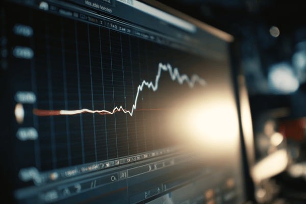 A computer monitor that has a descending line graph on its monitorr screen