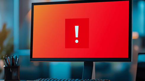 Computer monitor with red screen and white exclamation point