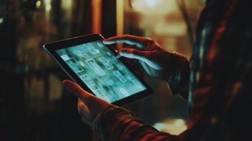 A person holding a tablet pointing to icons