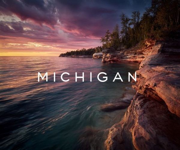the word "MICHIGAN" superimposed over a view of sunrise over a Great Lakes coastline in Michigan