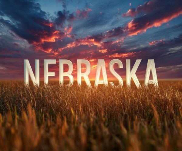 the word "NEBRASKA" superimposed over a scenic sunrise over a golden wheatfield
