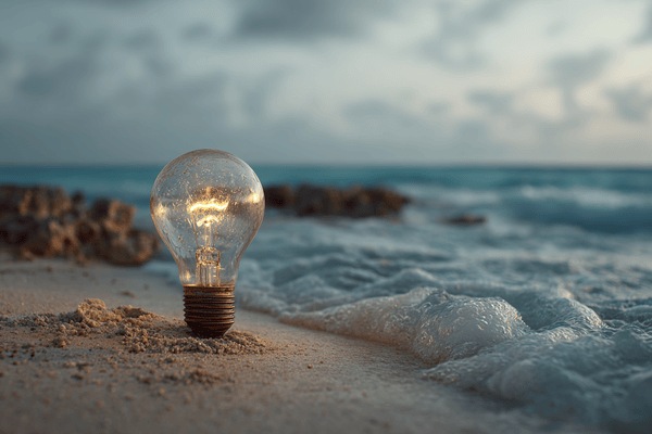 A light bulb lit up on a beach