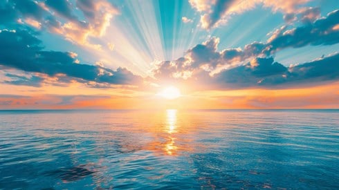 The ocean with a sunrise shining over it