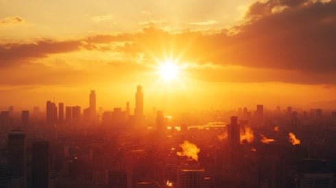 blazing hot sun over a city skyline