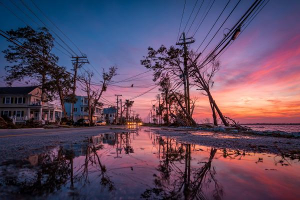 sunrise at a coastal residential area flooded and destroyed with downed powerlines and trees
