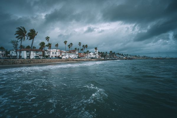 hurricane clouds moving in over residential buildings and rising shoreline