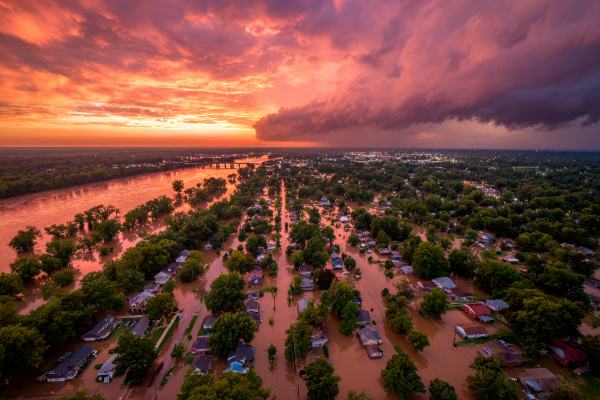 sunrise over a flooded town with storm clouds moving away