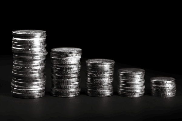 Five stacks of coins that decrease in height from left to right