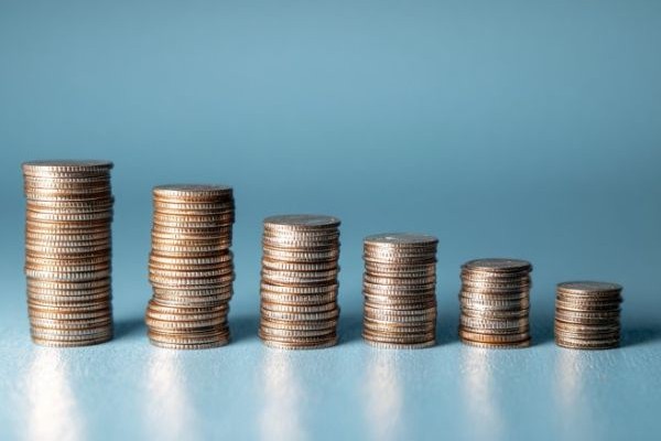stacks of silver coins decreasing in a line over a blue background