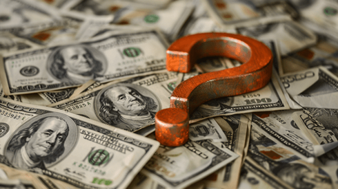 Orange metal question mark on top of a pile of money