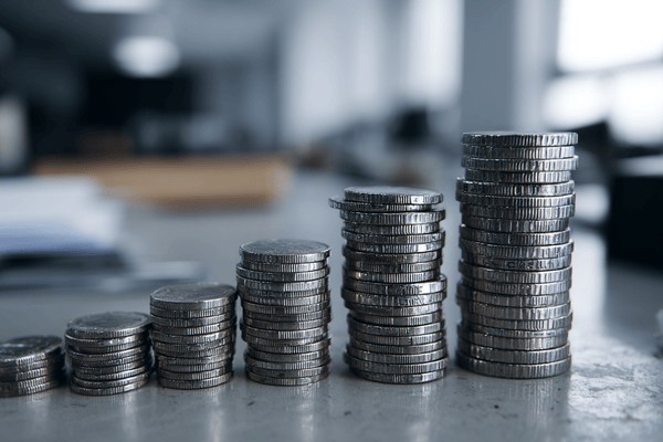 A row of coins increasing in height that are stacked on an office desk