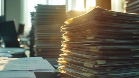 stack of tax forms in front of a sunny window