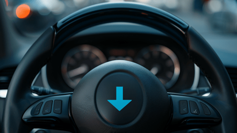 Steering wheel of a car with a downward blue arrow in the center of it