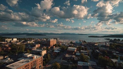 a wide angle view of Burlington Vermont with city and harbor with mountains in the distance