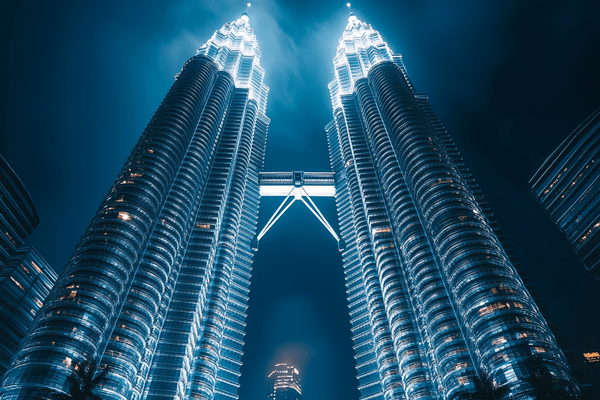 Low-angle nighttime shot of the Petronas Towers in Kuala Lumpur, Malaysia