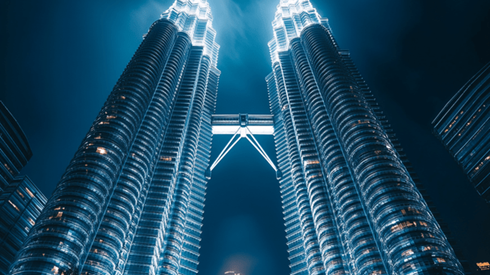Low-angle nighttime shot of the Petronas Towers in Kuala Lumpur, Malaysia