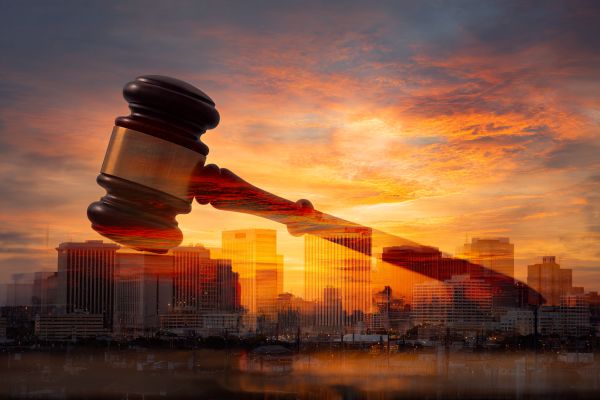 a semi-transparent gavel overlaid on the sunrise over the skyline of Baton Rouge Louisiana