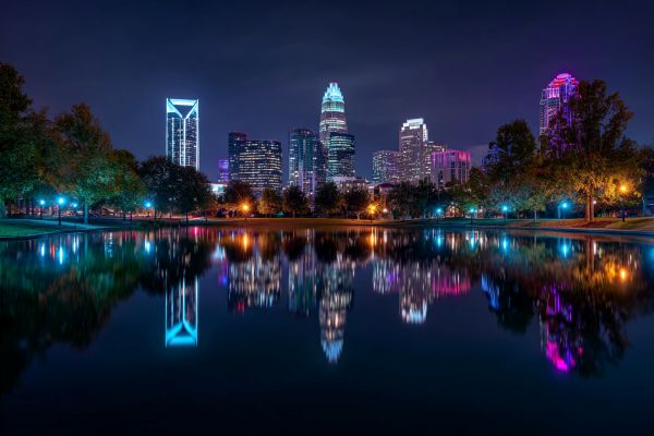 night skyline of Charlotte North Carolina lit up and reflected in water