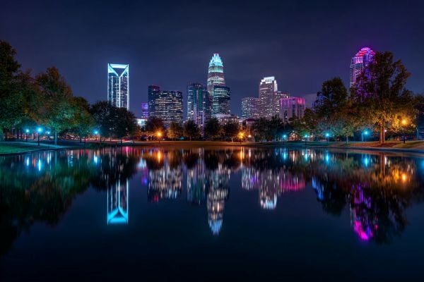 night skyline of Charlotte North Carolina lit up and reflected in water