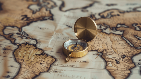 A gold compass laying on top of a world map